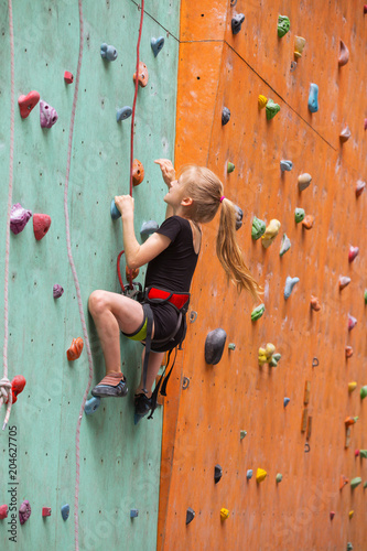 little girl climbing up the wall