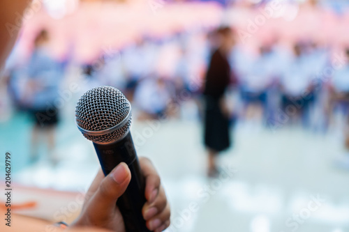 Seminar Conference Concept : hands holding businesspeople speech or speaking with microphones in seminar room, talking for lecture to audience university, Event light convention hall Background.