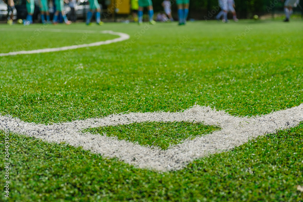 White stripe on Artificial green football soccer field from side view.