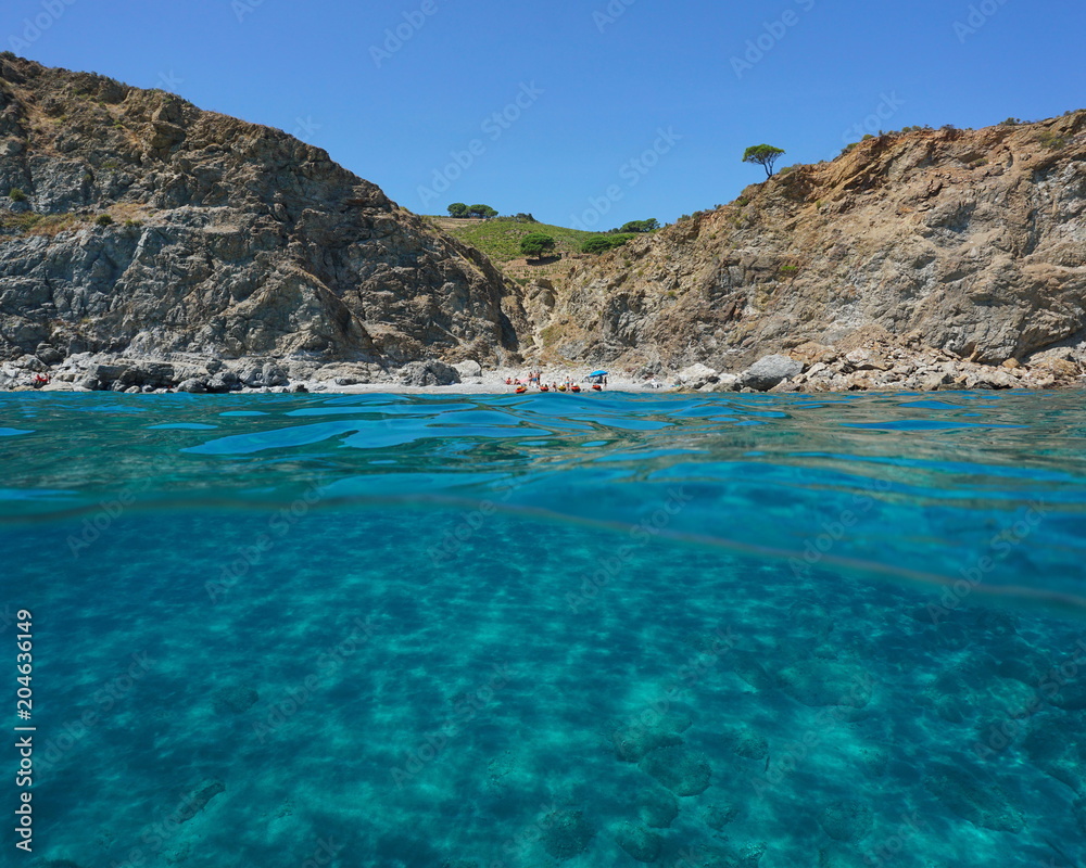 Rocky coast with a secluded beach and a sandy seabed underwater, split view above and below water surface, Mediterranean sea, Marine reserve of Cerbere Banyuls, Pyrenees Orientales, France
