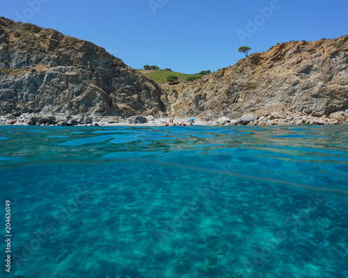 Rocky coast with a secluded beach and a sandy seabed underwater, split view above and below water surface, Mediterranean sea, Marine reserve of Cerbere Banyuls, Pyrenees Orientales, France