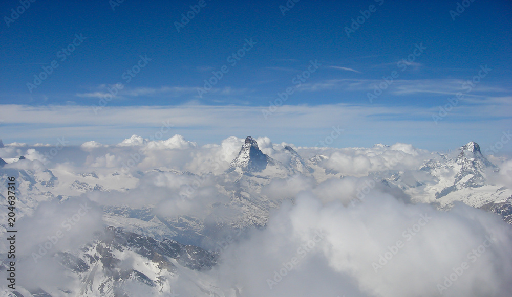panorama view of the Matterhorn and surrounding mountains on a beautiful winter day above a sea of clouds