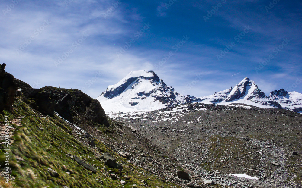 hiking trail leading to snow-capped peaks with a great view of the Gran Paradiso national Park in the Italian Alps