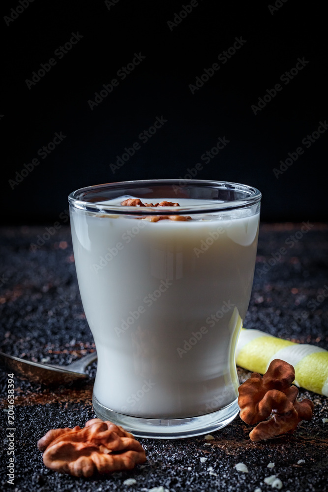 Layered greek yogurt parfait with nut and cornet in a glass. Healthy breakfast. Dark food photography. Close up, vertical Layered greek yogurt parfait with nut and cornet in a glass. Healthy breakfast. Dark food photography. Close up, vertical