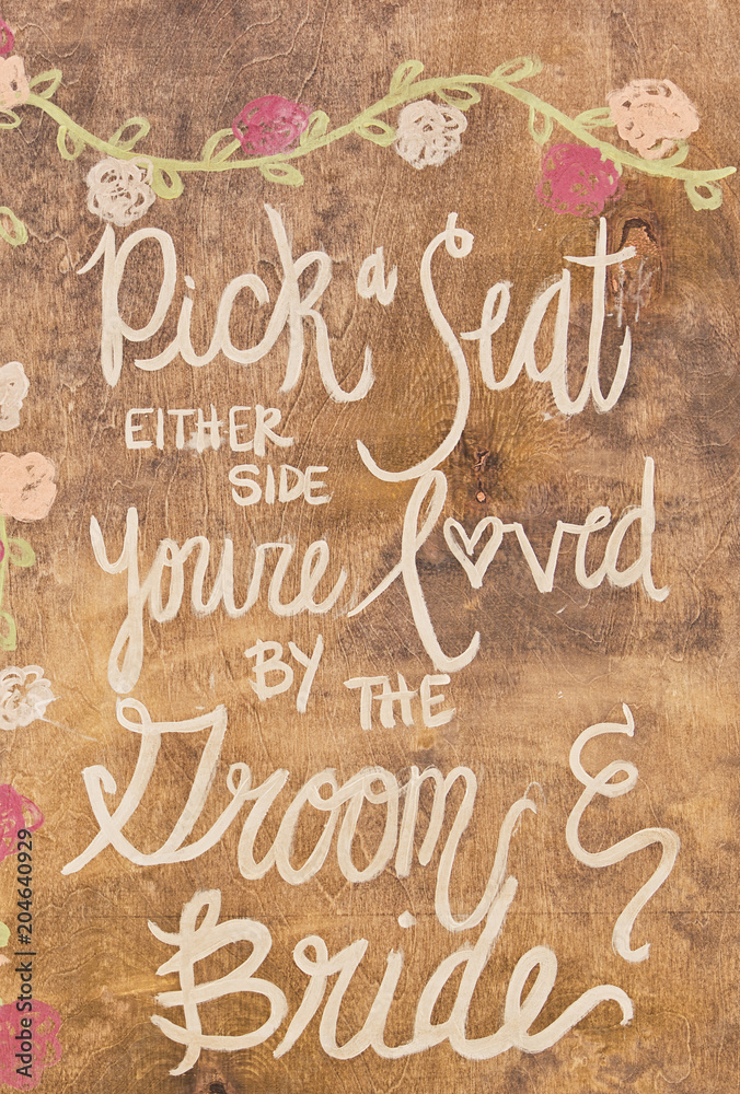 Obraz premium Pick a seat either side you're loved by the groom and bride sign