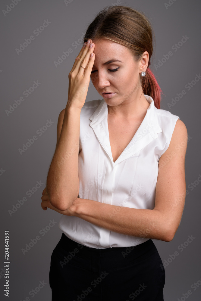 Young beautiful businesswoman against gray background Young beautiful businesswoman against gray background