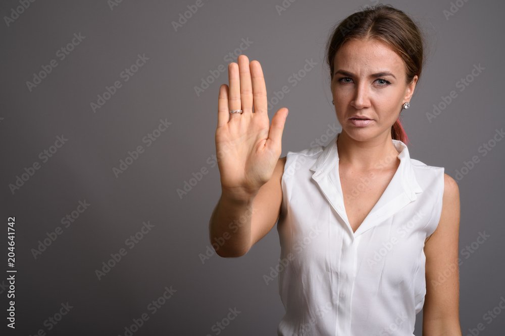 Young beautiful businesswoman against gray background Young beautiful businesswoman against gray background