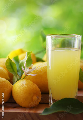 ripe lemons and juice cup on table