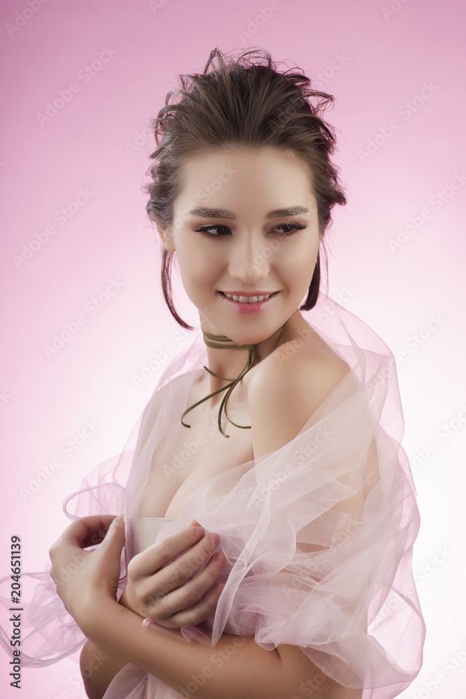 Beautiful smiling young big breast asian girl wearing pink veil on her naked shoulders and a choker on her neck sensually puts her hands on her chest. Beautiful smiling young big breast asian girl wearing pink veil on her naked shoulders and a choker on her neck sensually puts her hands on her chest.
