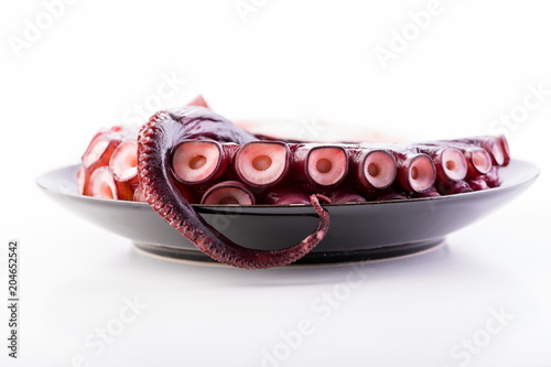 Beautiful octopus tentacle on the black plate
