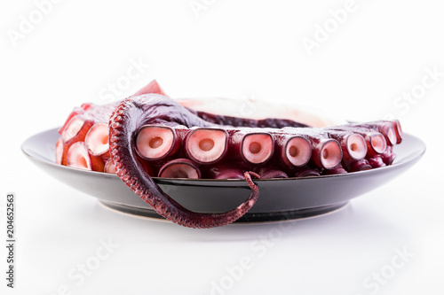 Beautiful octopus tentacle on the black plate