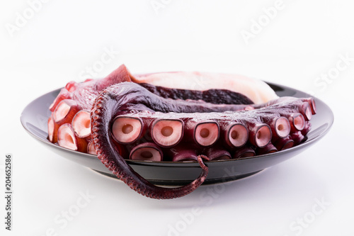 Beautiful octopus tentacle on the black plate