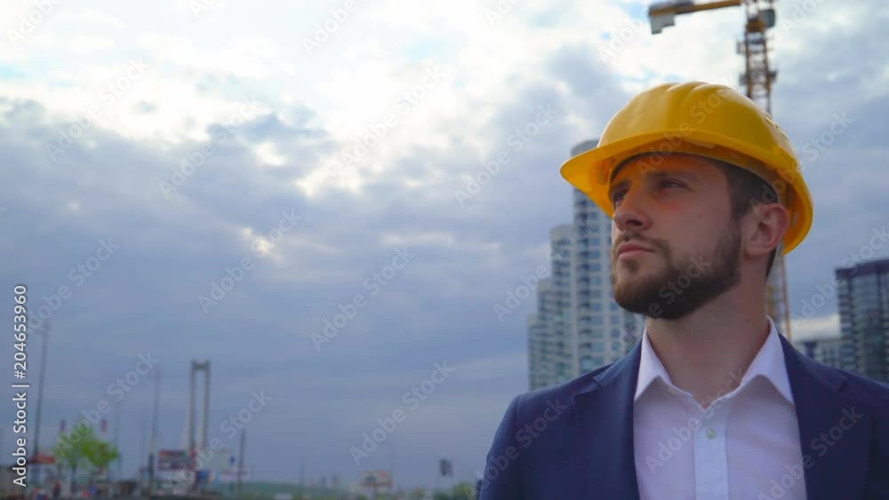 young man builder smiling on building background. Close-up portrait of a man. a man is happy for the work done. 4k young man builder smiling on building background. Close-up portrait of a man. a man is happy for the work done. 4k