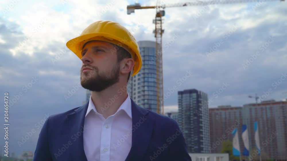 young man builder smiling on building background. Close-up portrait of a man. a man is happy for the work done. 4k young man builder smiling on building background. Close-up portrait of a man. a man is happy for the work done. 4k