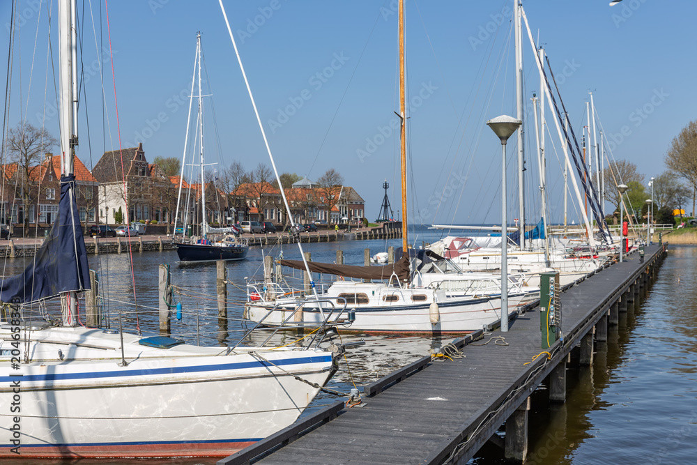 Harbor Dutch city Medemblik with modern yachts moored to wooden jetty Harbor Dutch city Medemblik with modern yachts moored to wooden jetty