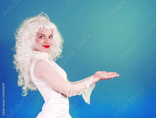 Portrait of a beautiful young woman holding something on her hand. Product on her hand in front of a bright colored background. Girl showing with copy space.