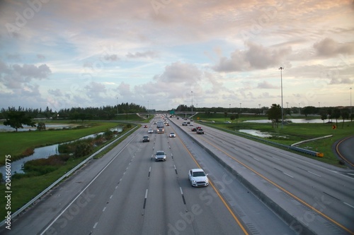 Traffic Moves Smoothly along the Florida Turnpike at Sample Road in Pompano Beach, Florida after Rush Hour at Dusk with a Brown Graduated Filter to Accentuate the Clouds in the Sky