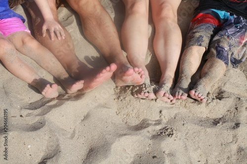 Parents' and Children's Legs with Feet in the Beach Sand, Various Colored Shorts, Sunny Afternoon in Florida in December