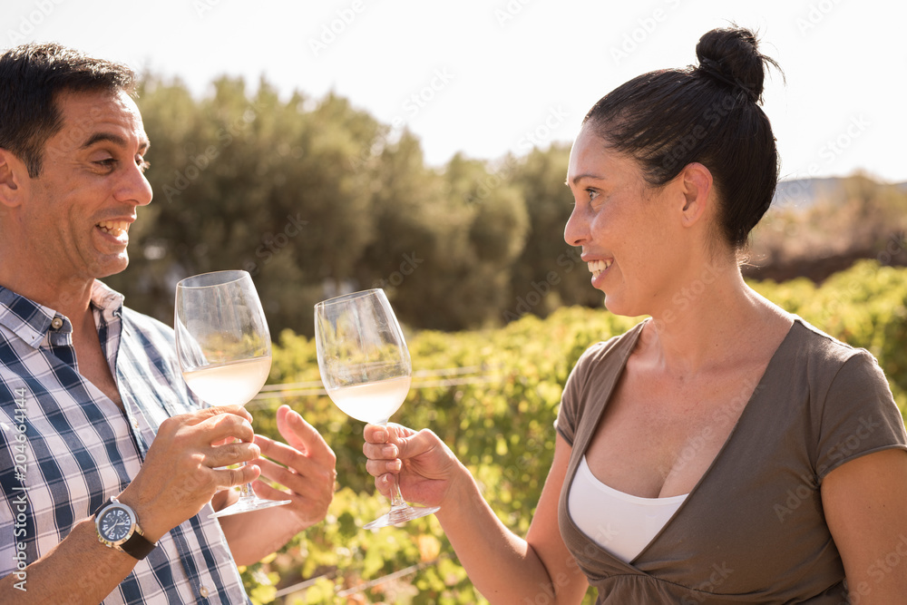 A man and woman drinking wine in a vineyard A man and woman drinking wine in a vineyard