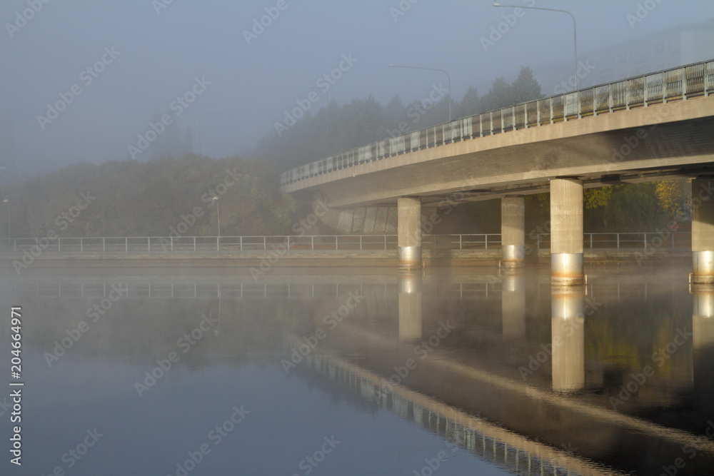 Bridge over misty and calm lake 