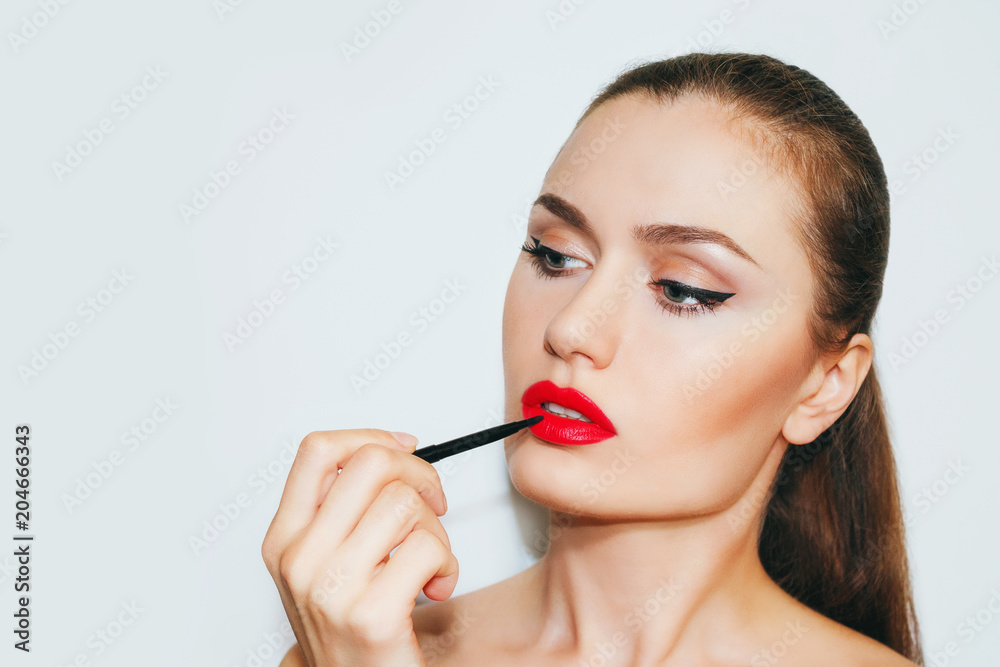 Beautiful woman with beautiful make-up with red lips . Woman paints her lips with a brush for make-up . Make-up artist , beautiful makeup , salon. Beautiful woman with beautiful make-up with red lips . Woman paints her lips with a brush for make-up . Make-up artist , beautiful makeup , salon.