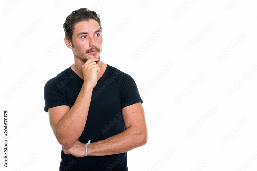 Studio shot of young handsome man thinking while looking up isol Studio shot of young handsome man thinking while looking up isol