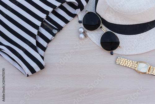 Female outfit and accessories for travel preparations with concept holiday on wood background.