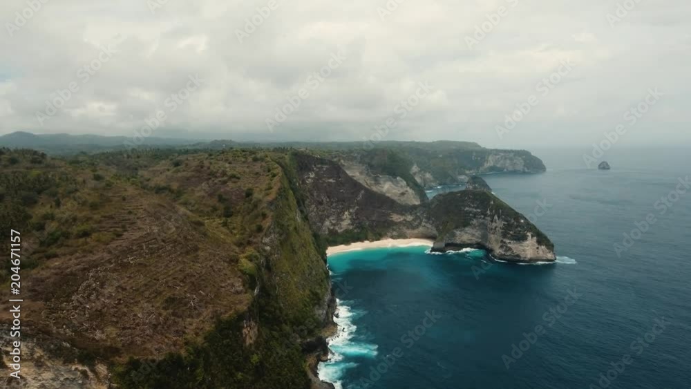 Tropical beach among rocky cliffs. Karang Dawa, Manta Bay or Kelingking Beach on Nusa Penida Island, Bali, Indonesia. 4K video. Travel concept. Aerial footage Tropical beach among rocky cliffs. Karang Dawa, Manta Bay or Kelingking Beach on Nusa Penida Island, Bali, Indonesia. 4K video. Travel concept. Aerial footage