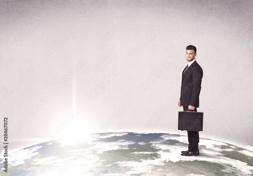 A young elegant office worker standing on top of a drawn world globe while celebrating his successful career concept. A young elegant office worker standing on top of a drawn world globe while celebrating his successful career concept.