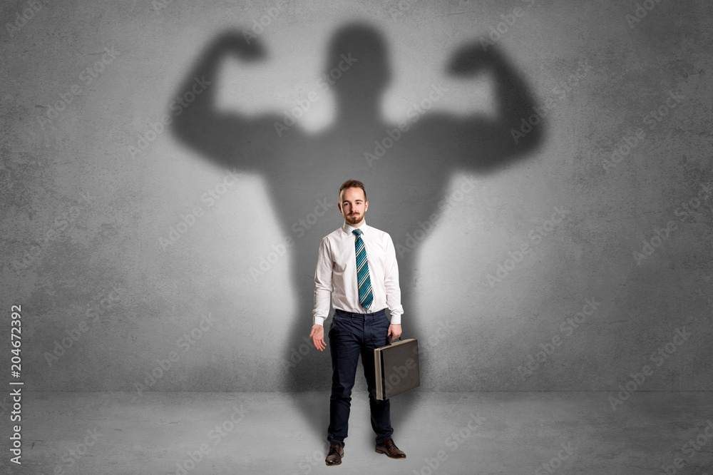 Lovely serious businessman standing with a muscular powerful shadow behind his back
Lovely serious businessman standing with a muscular powerful shadow behind his back