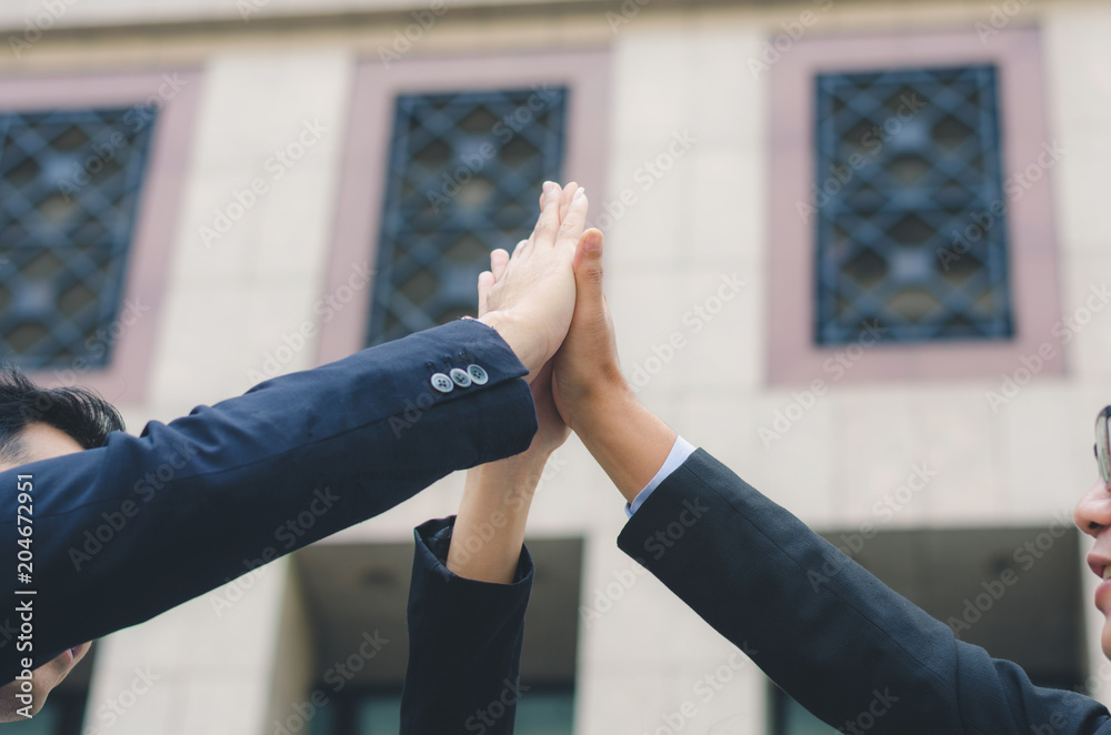 teamwork concept of diversity multiethnic business people with group high five hands bump for relationship and success together front of office building.
