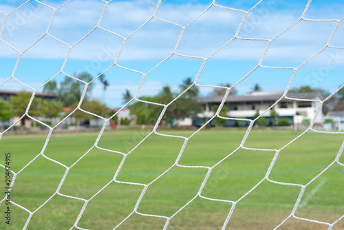 Dirty football net on the field with bright atmosphere.