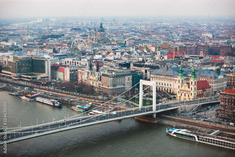 Obraz premium Beautuful super-wide angle aerial view of Budapest, Hungary, with Danube river and scenery beyond the city, seen from observation point of Gellert Hill