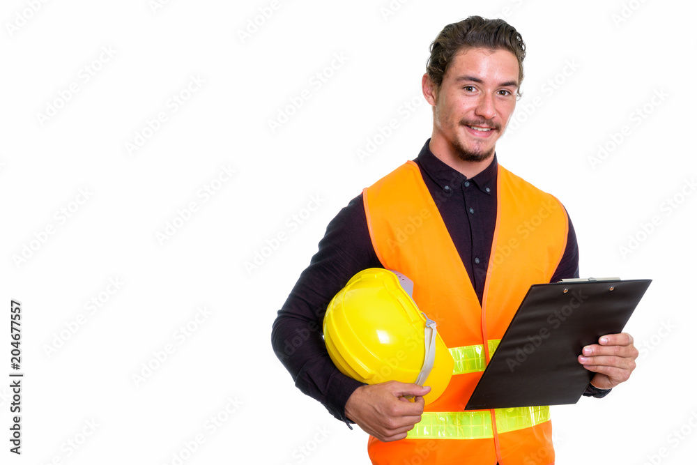 Studio shot of young happy man construction worker smiling while Studio shot of young happy man construction worker smiling while