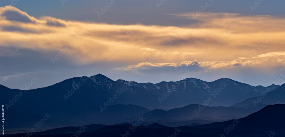 Panorama of the mountains on a hazy, but colorful sunset evening