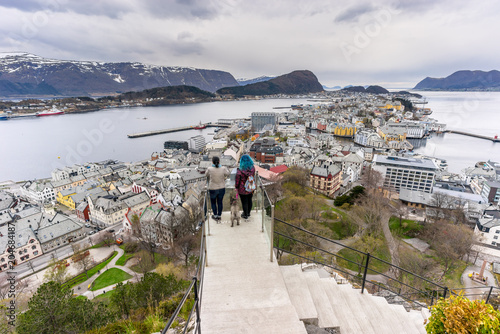 People and dog enjoying the view of Alesund from the Byrampen platform in Mount Aksla