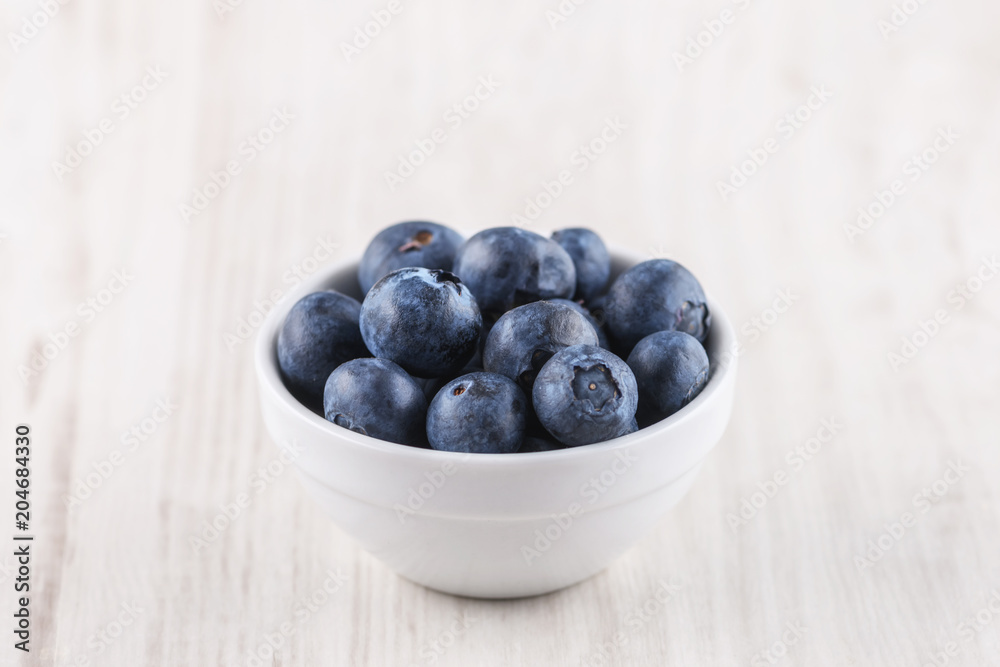 bowl with blueberries on a wooden background bowl with blueberries on a wooden background