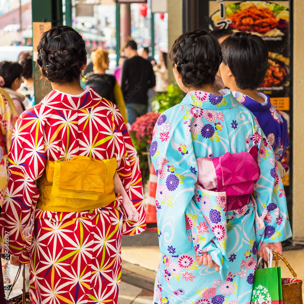 Two girls in a kimono on a city street in Kyoto, Japan. Close-up.