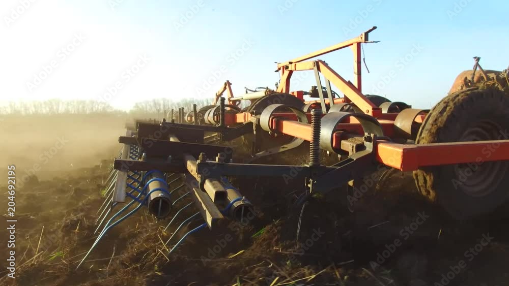 Farmer in tractor soil plows Russia steadicam motion agriculture the ground preparing land with seedbed cultivator as part of pre seeding activities in early spring season of agricultural works at Farmer in tractor soil plows Russia steadicam motion agriculture the ground preparing land with seedbed cultivator as part of pre seeding activities in early spring season of agricultural works at