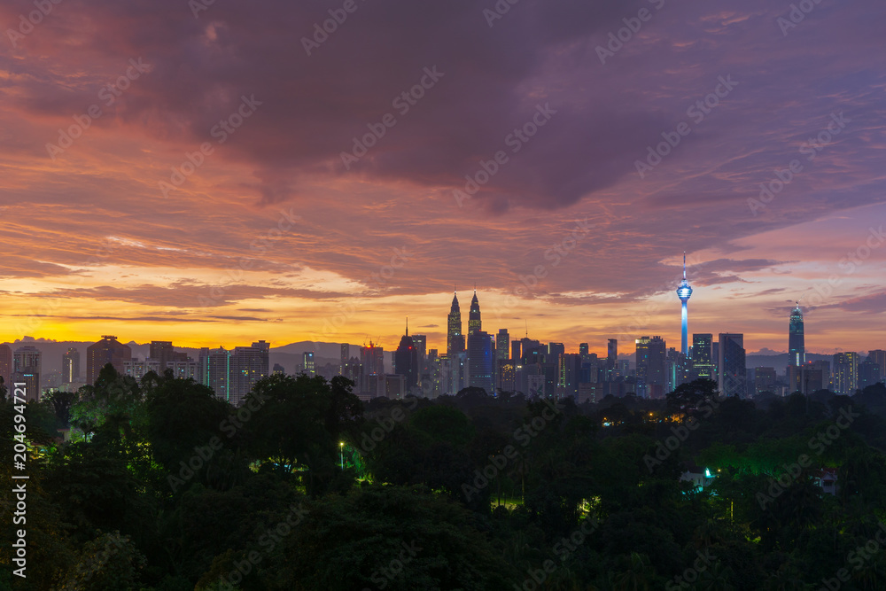 Fototapeta premium Majestic sunrise over Petronas Twin Towers and surrounded buildings in downtown Kuala Lumpur, Malaysia.