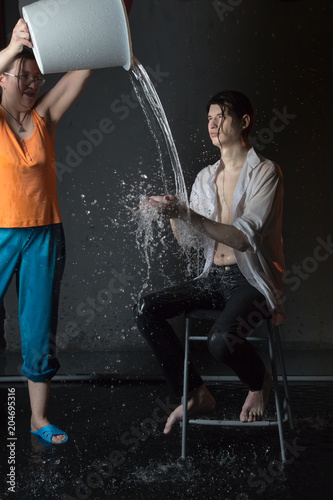 Attractive young man brunette and his assistant during studio photo shoot