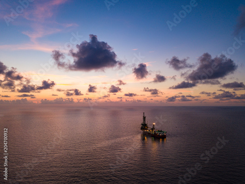 Aerial View of Tender Drilling Oil Rig (Barge Oil Rig) in The Middle of The Ocean at Sunset Time © bomboman