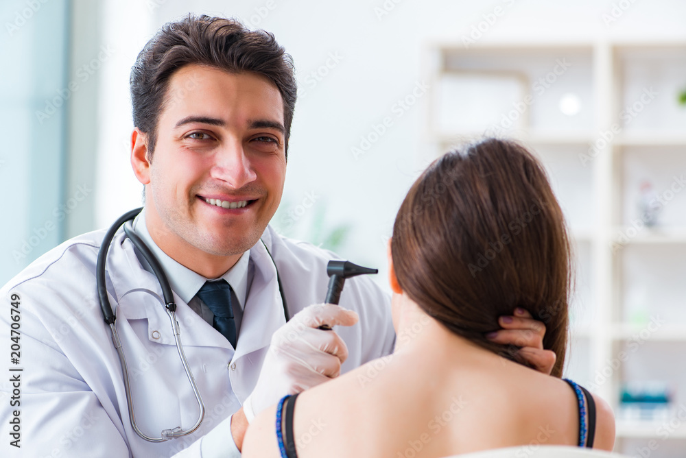 Doctor checking patients ear during medical examination Doctor checking patients ear during medical examination