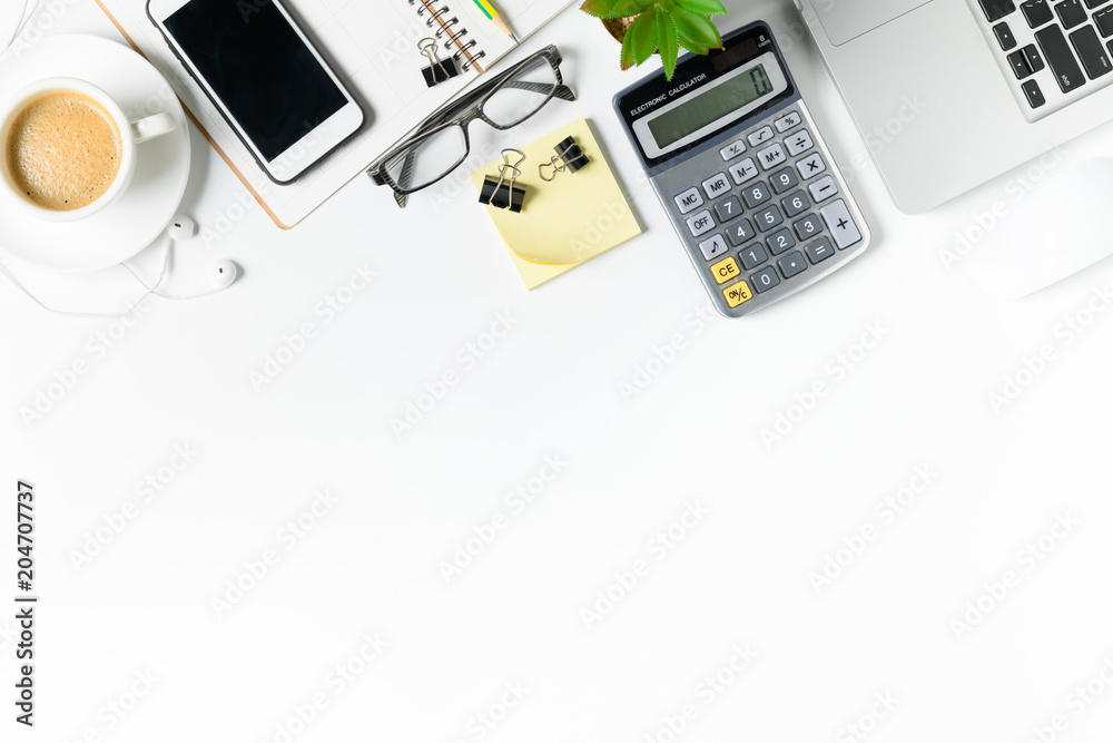 white office desk table with laptop, smartphone and supplies white office desk table with laptop, smartphone and supplies