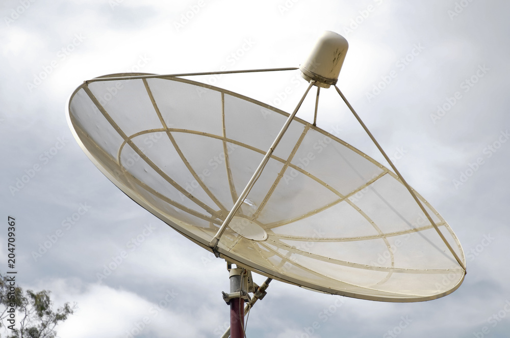 Modern satellite reception dish and cloudy sky