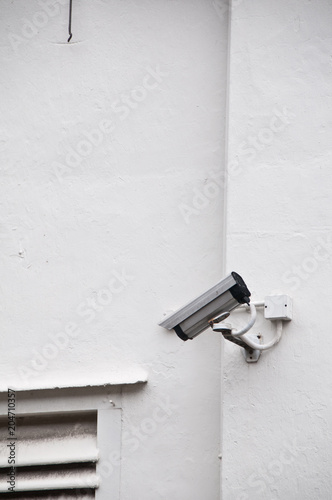 Surveillance camera on white wall