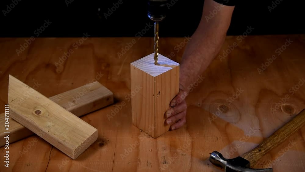 Drilling a three quarter inch hole in a square block of lumber Stock