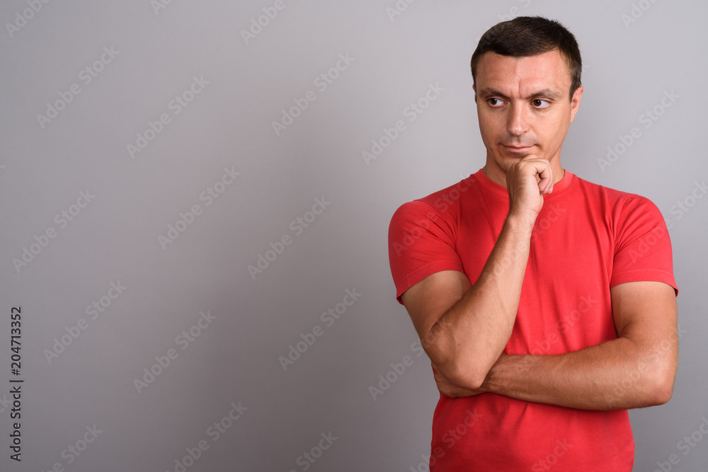 Man wearing red shirt against gray background Man wearing red shirt against gray background