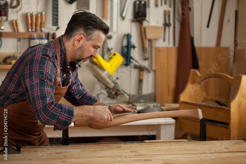 Joiner Makes Cabriole Leg for Vintage Table. Carpenter works with a planer in a workshop 