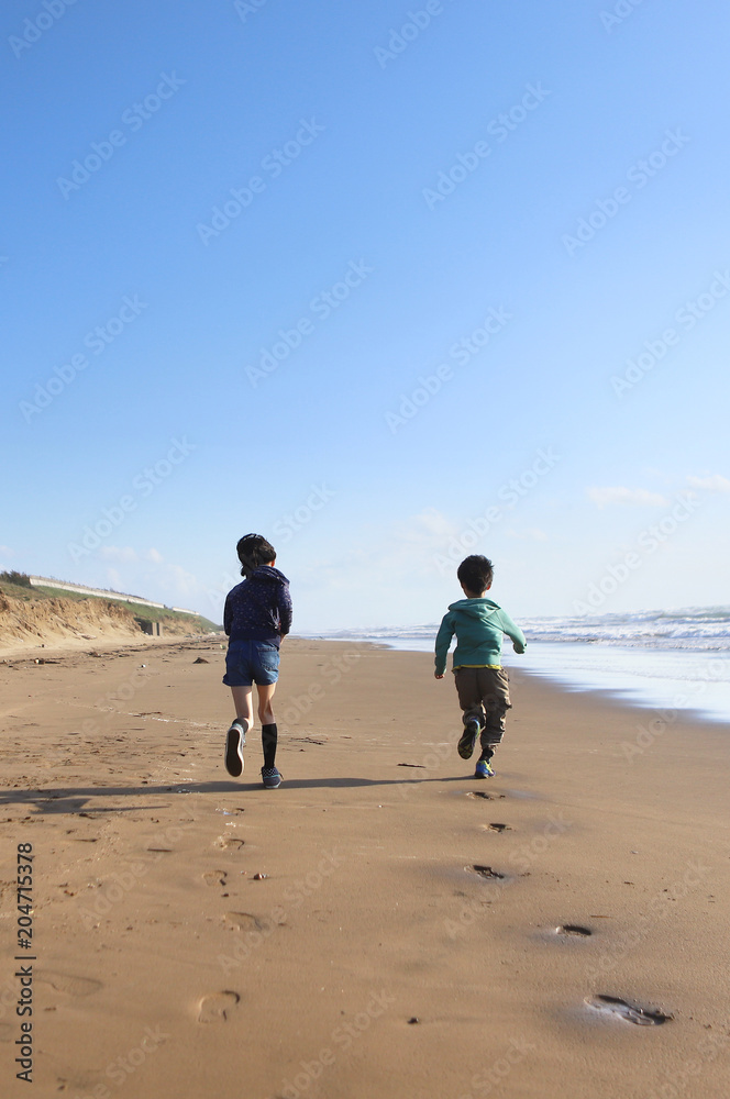 Naklejka premium 砂浜を走る子どもたち